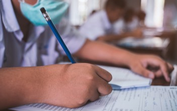 Calendrier des concours et examens professionnels 2021 – 2022 Students wearing mask for protect corona virus or covid-19 and doing exam in classroom with stress.